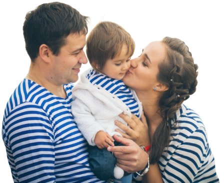 A mother and father hold their child together and kiss his cheeks.